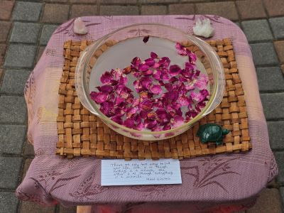 bowl of water and rose petals on an altar