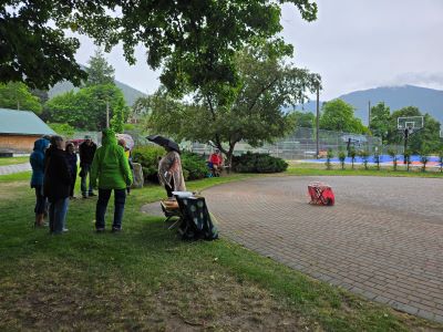 people gathered at the side of a brick paver labyrinth surrounded by trees