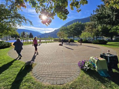 people walking a brick paver labyrinth surrounded by trees