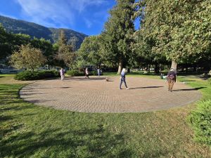 people walking a brick paver labyrinth surrounded by trees