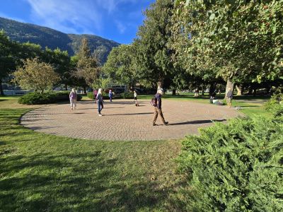 people walking a brick paver labyrinth surrounded by trees