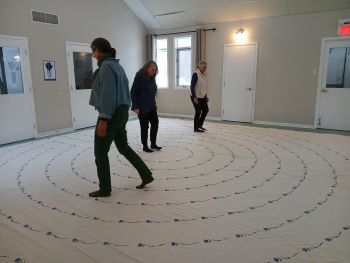three people walking a cloth labyrinth