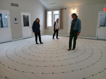 three people walking a cloth labyrinth