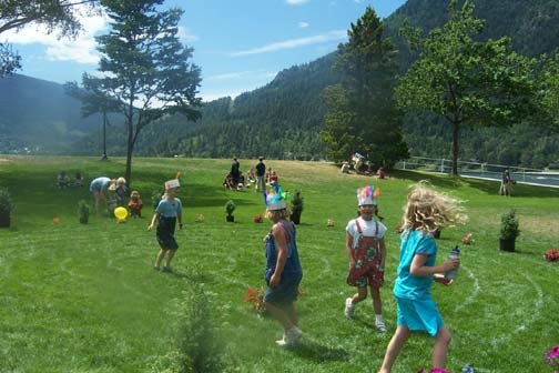  Children running around a labyrinth painted on grass in a park setting   